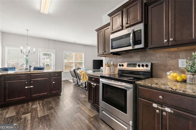 kitchen featuring backsplash, pendant lighting, stainless steel appliances, dark wood-type flooring, and dark brown cabinets