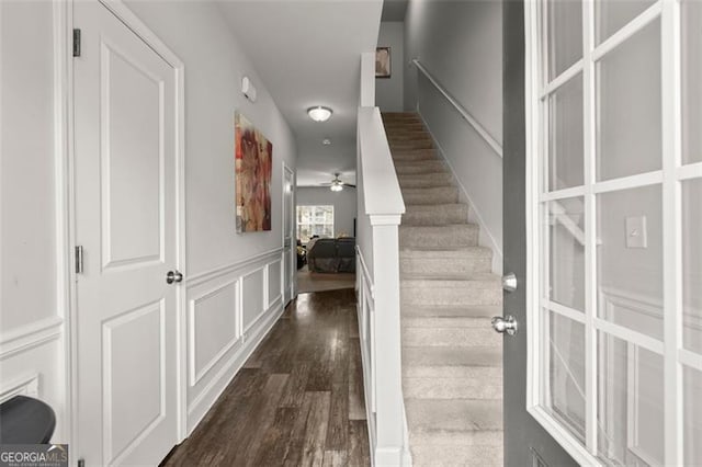 staircase with hardwood / wood-style flooring and ceiling fan