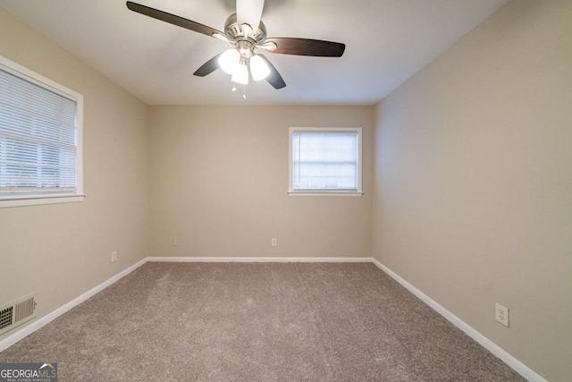 carpeted spare room featuring ceiling fan