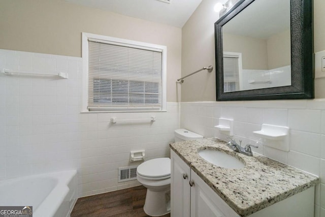 bathroom with wood-type flooring, tile walls, vanity, and toilet