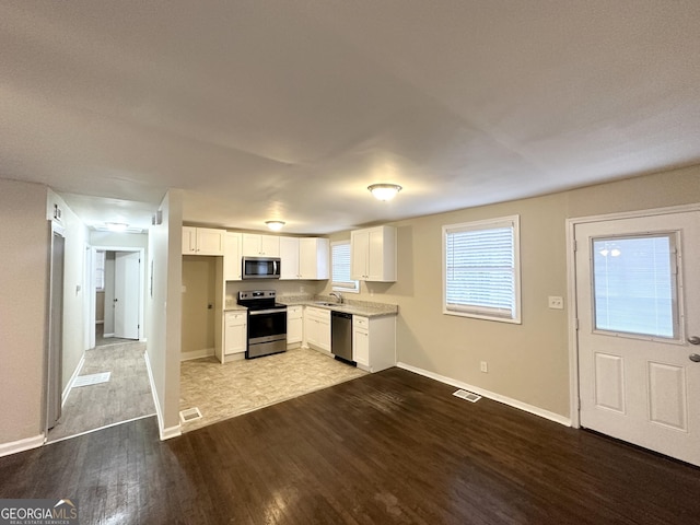 360 Belgarde Pl, Atlanta, GA 30354 - kitchen with appliances with stainless steel finishes, wood finished floors, light countertops, and white cabinets