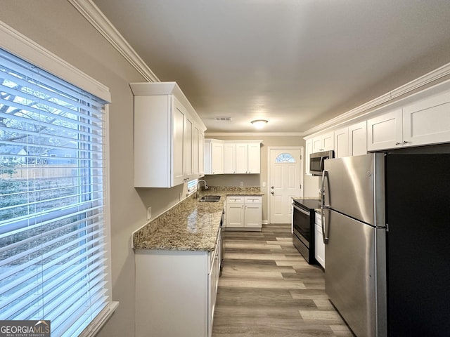1158 Edgefield Dr SW, Atlanta, GA 30310 - kitchen with stainless steel appliances, white cabinetry, wood finished floors, stone counters, and ornamental molding