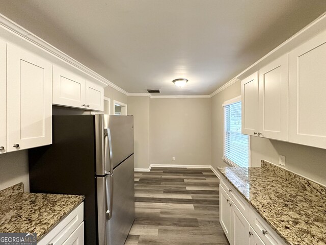 1158 Edgefield Dr SW, Atlanta, GA 30310 - kitchen with freestanding refrigerator, ornamental molding, white cabinets, dark wood finished floors, and light stone counters