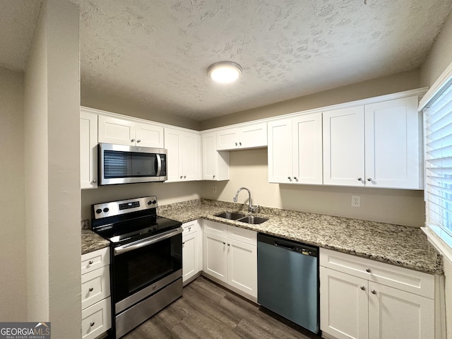 2174 Doris Dr, Decatur, GA 30034 - kitchen with appliances with stainless steel finishes, dark wood-style floors, healthy amount of natural light, white cabinetry, and a textured ceiling