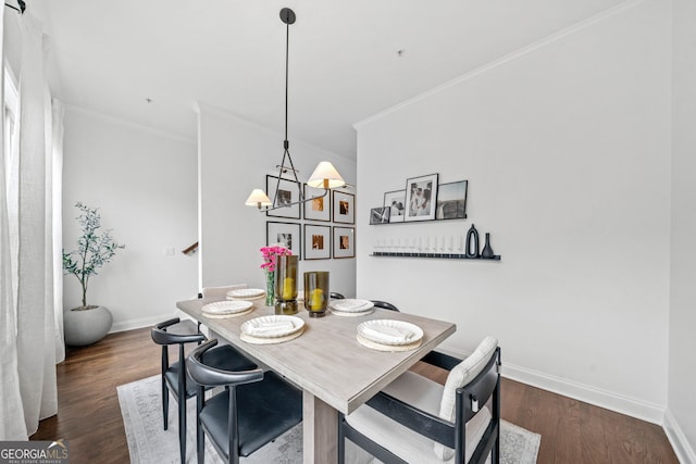 dining area with an inviting chandelier, crown molding, and dark hardwood / wood-style floors