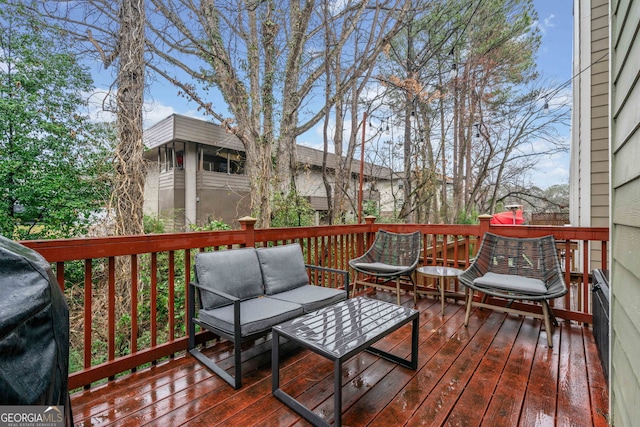 wooden deck with an outdoor living space and a grill