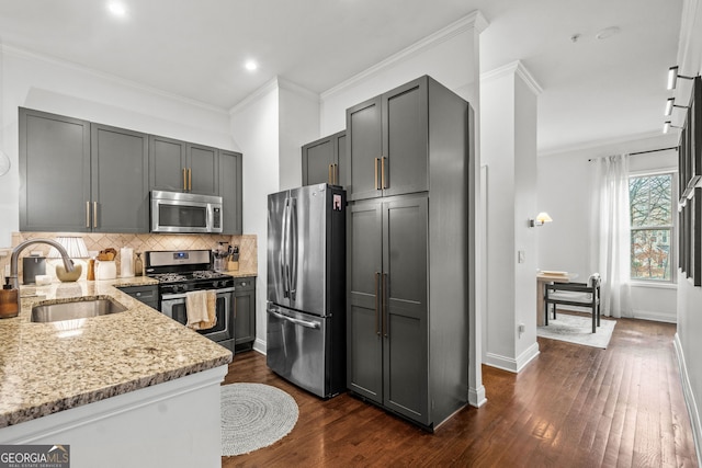 kitchen with sink, gray cabinetry, stainless steel appliances, light stone countertops, and backsplash