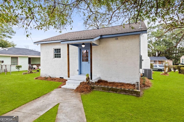 view of front of house with central AC unit and a front lawn