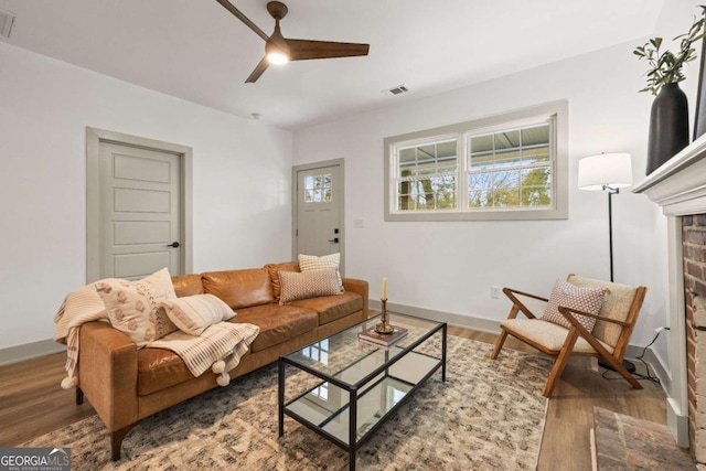 living room featuring dark wood-type flooring, ceiling fan, and plenty of natural light