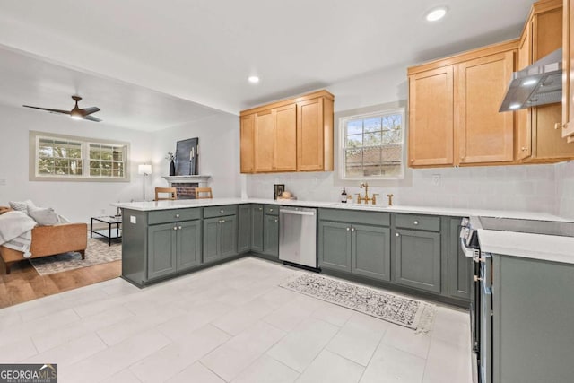 kitchen with sink, ceiling fan, appliances with stainless steel finishes, tasteful backsplash, and kitchen peninsula