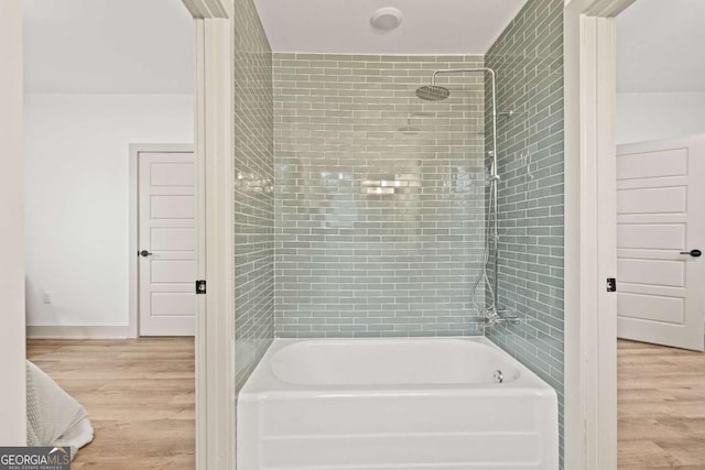 bathroom featuring tiled shower / bath and hardwood / wood-style floors