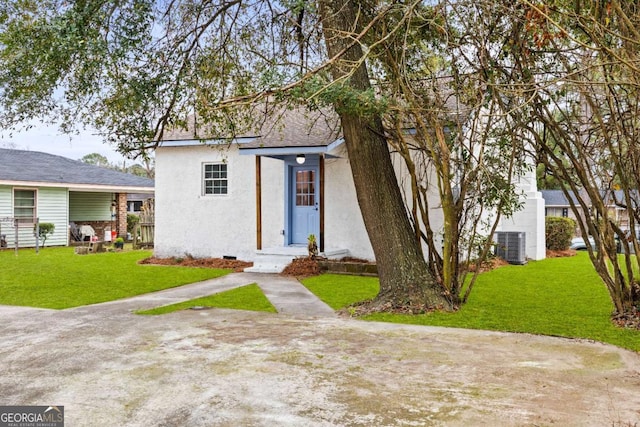 view of front facade with a front lawn and central air condition unit