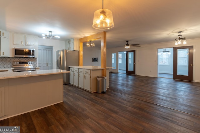 kitchen with white cabinetry, tasteful backsplash, plenty of natural light, pendant lighting, and stainless steel appliances