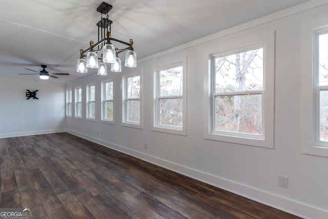 unfurnished dining area featuring a healthy amount of sunlight, dark hardwood / wood-style floors, and a notable chandelier