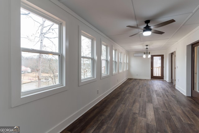 unfurnished sunroom with ceiling fan with notable chandelier and a wall mounted AC