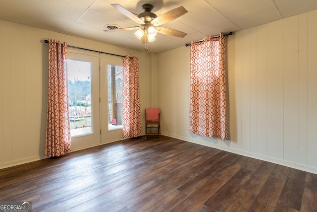 empty room featuring dark wood-type flooring and ceiling fan