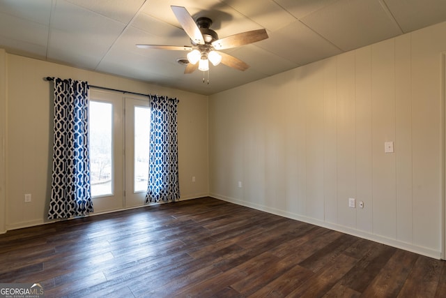 unfurnished room with ceiling fan and dark hardwood / wood-style flooring