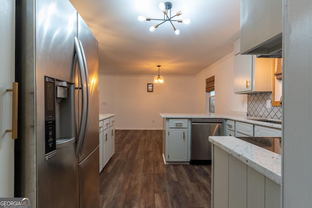 kitchen with pendant lighting, appliances with stainless steel finishes, dark hardwood / wood-style floors, tasteful backsplash, and kitchen peninsula