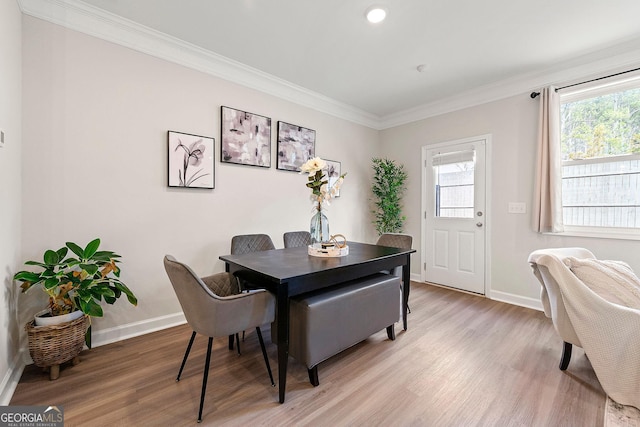 dining space with hardwood / wood-style floors, plenty of natural light, and crown molding