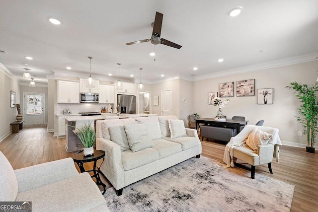 living room featuring light wood-type flooring, crown molding, and ceiling fan