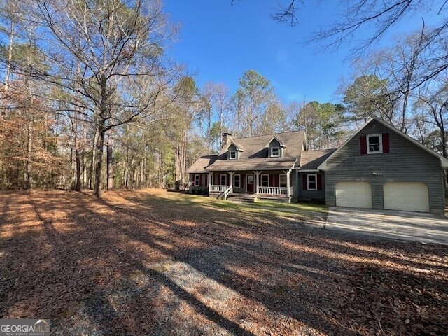 cape cod-style house with a garage and a porch