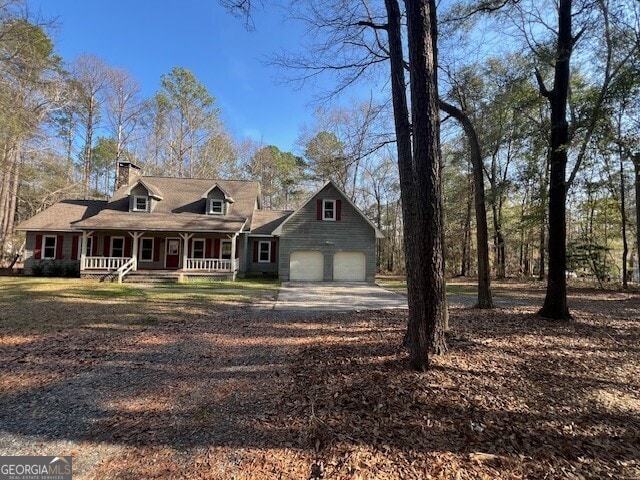 new england style home featuring a garage and covered porch