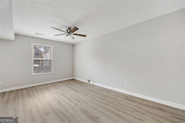 spare room featuring ceiling fan, a textured ceiling, and light wood-type flooring