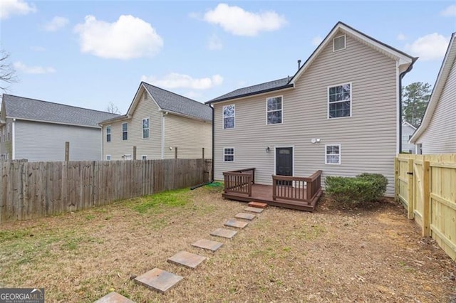 rear view of house featuring a yard and a deck