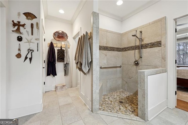 bathroom with tile patterned flooring, ornamental molding, and tiled shower