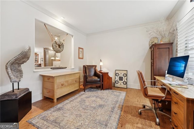 office area with crown molding and light wood-type flooring