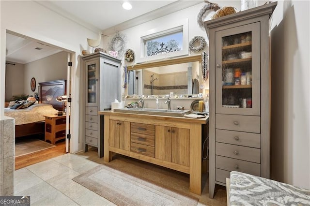 bathroom with tile patterned flooring, vanity, crown molding, and walk in shower