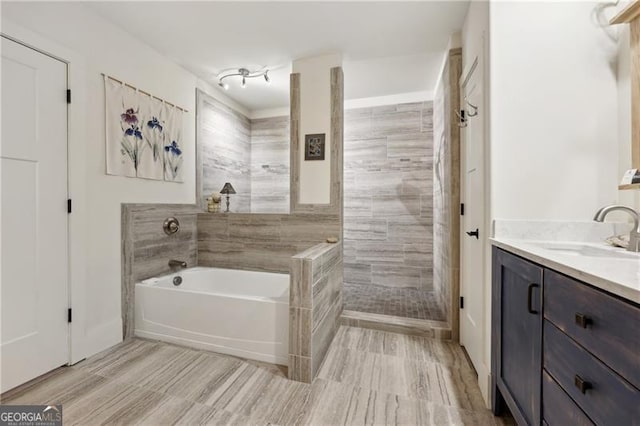 bathroom featuring vanity and shower with separate bathtub