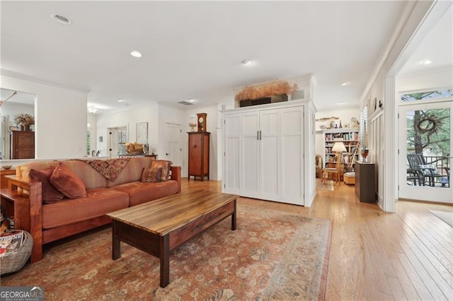 living room with ornamental molding and light wood-type flooring