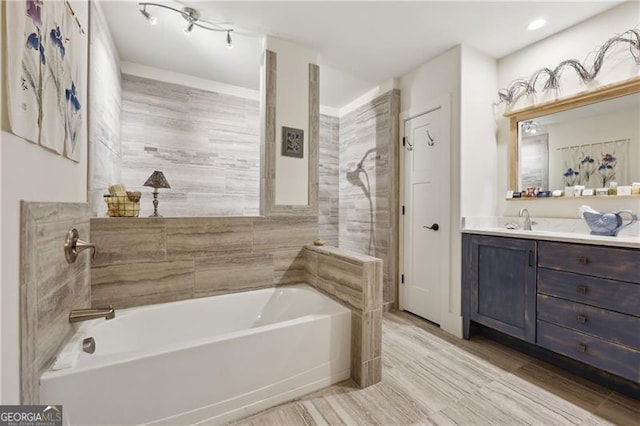 bathroom featuring vanity, hardwood / wood-style floors, and a tub