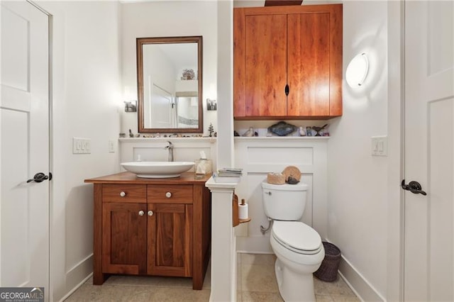 bathroom featuring vanity, tile patterned floors, and toilet