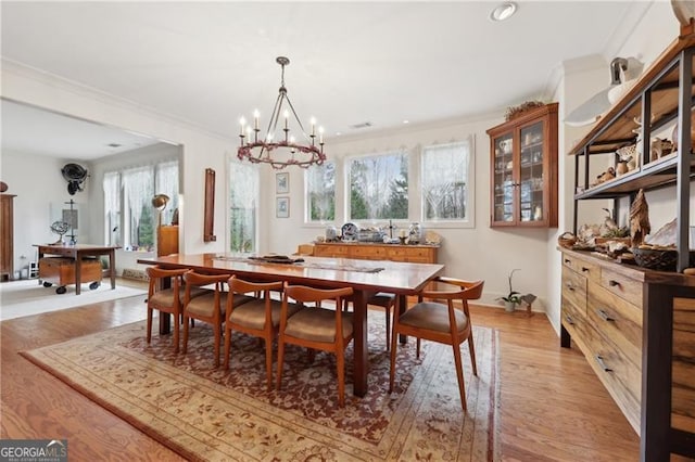 dining room featuring a notable chandelier, crown molding, and light hardwood / wood-style flooring