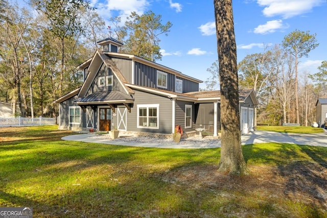 rear view of property with a garage and a lawn