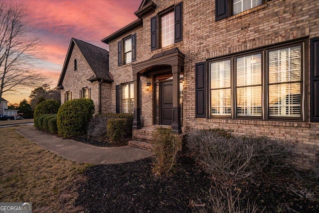 view of exterior entry with brick siding