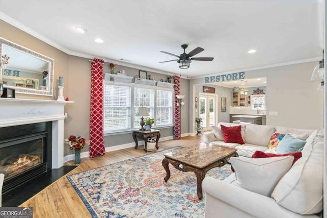 7856 Keepsake Ln, Flowery Branch, GA 30542 - living area with ornamental molding, ceiling fan, recessed lighting, a fireplace with flush hearth, and wood finished floors