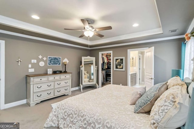7856 Keepsake Ln, Flowery Branch, GA 30542 - bedroom featuring crown molding, a tray ceiling, a walk in closet, a closet, and light colored carpet