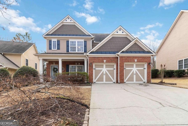 view of front of house with a garage, concrete driveway, brick siding, and a standing seam roof