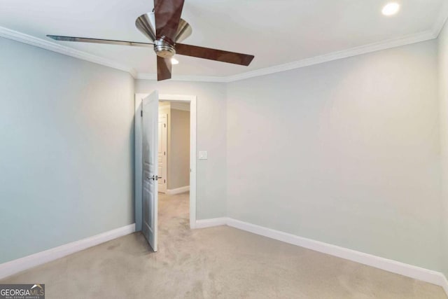 carpeted spare room with crown molding and ceiling fan