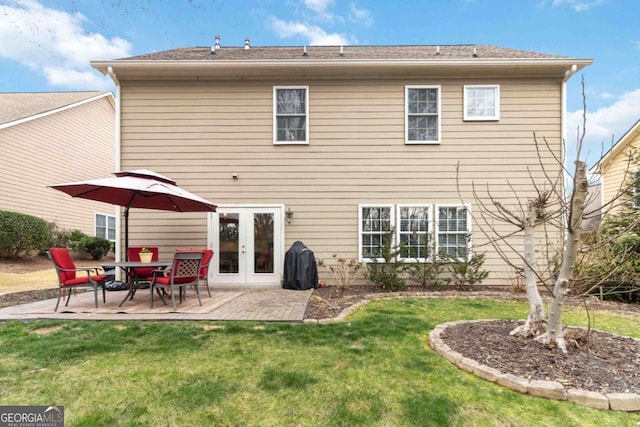 back of house featuring a patio, a lawn, and french doors