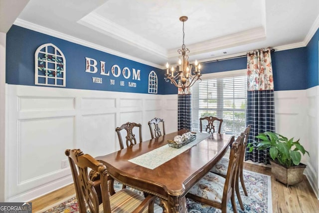 7856 Keepsake Ln, Flowery Branch, GA 30542 - dining room with a tray ceiling, a chandelier, ornamental molding, a decorative wall, and wainscoting
