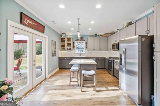 7856 Keepsake Ln, Flowery Branch, GA 30542 - kitchen with stainless steel appliances, a center island, gray cabinets, french doors, and tasteful backsplash