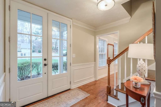 doorway to outside with ornamental molding and wood-type flooring