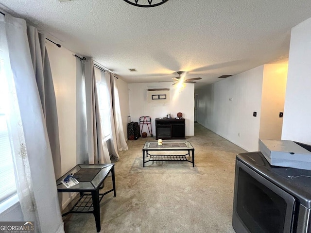 living room with ceiling fan, light colored carpet, and a textured ceiling