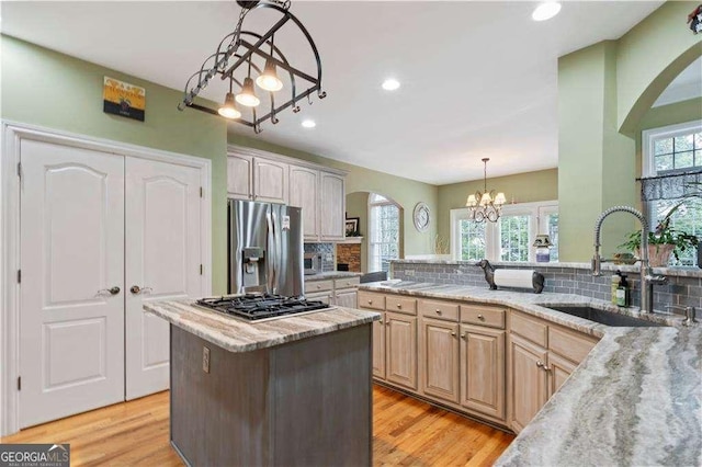 3130 Kates Way NW, Kennesaw, GA 30152 - kitchen with a sink, appliances with stainless steel finishes, a chandelier, arched walkways, and decorative backsplash