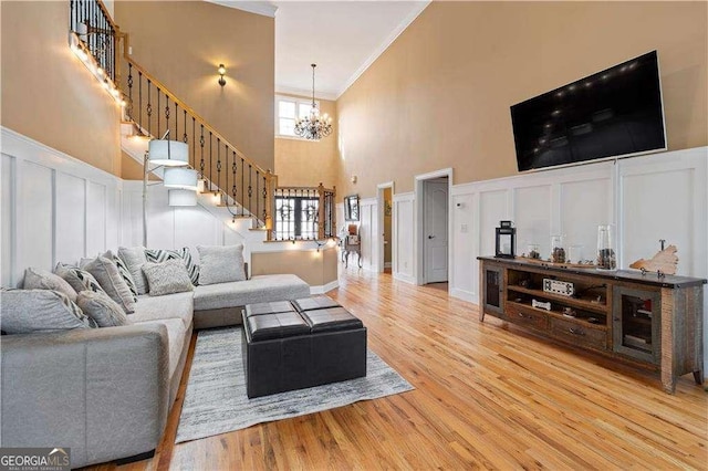 3130 Kates Way NW, Kennesaw, GA 30152 - living room with ornamental molding, a towering ceiling, stairway, a chandelier, and a decorative wall