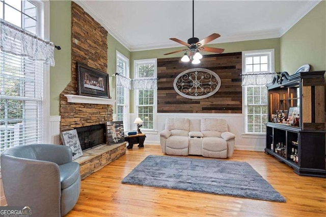 3130 Kates Way NW, Kennesaw, GA 30152 - living area with a stone fireplace, ceiling fan, wood finished floors, crown molding, and wainscoting